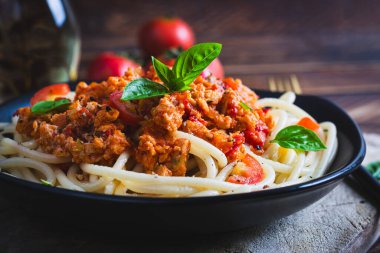 Spagetti makarna ve domates sosu ve ahşap arka planda tavuk kıyması. Makarna bolonez.