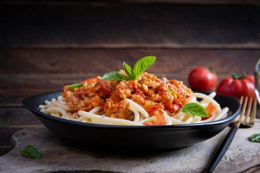 Spagetti makarna ve domates sosu ve ahşap arka planda tavuk kıyması. Makarna bolonez.