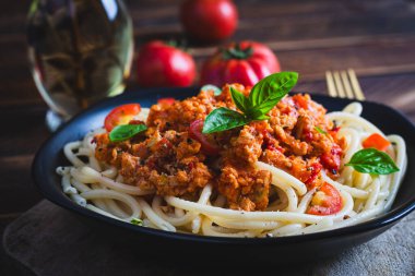 Spagetti makarna ve domates sosu ve ahşap arka planda tavuk kıyması. Makarna bolonez.