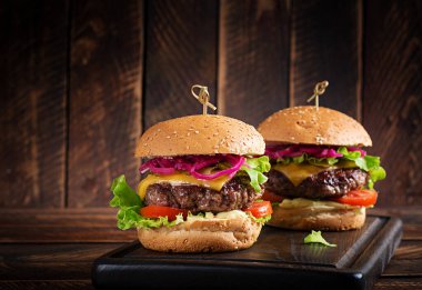 Sığır burger. Biftekli sandviç, domates, peynir, salatalık turşusu ve marul. Çizburger..