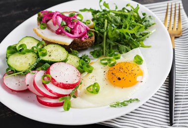 Kahvaltıda. Yağda yumurta, taze sebze salatası ve domuz yağlı sandviç. Keto diyeti