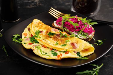 Kahvaltıda. Sosisli omlet, tatlı biber ve marine edilmiş kırmızı soğanlı sandviç. Frittata - İtalyan omleti.