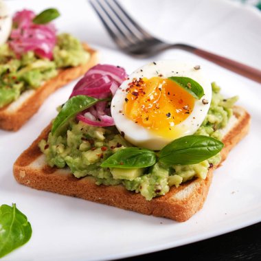 Avokado püresi, haşlanmış yumurta, baharat ve kırmızı soğanlı sağlıklı tost. Lezzetli kahvaltı ya da atıştırmalık.