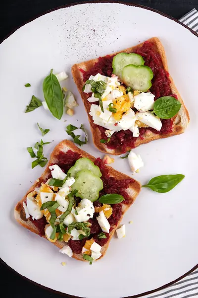 Pate pancar, haşlanmış yumurta, fesleğen ve salatalıklı sağlıklı tost. Lezzetli kahvaltı ya da atıştırmalık. Üst görünüm