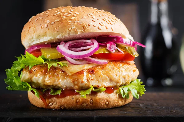 Chicken hamburger. Sandwich with chicken burger, tomatoes, cheese and lettuce. Cheeseburger.