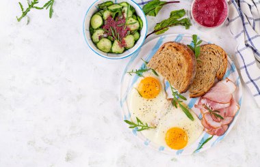 Kahvaltıda. Kızarmış yumurta, bir dilim jambon, kızarmış ekmek ve pancar püresi. Üst görünüm