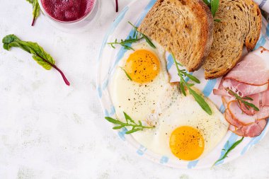Kahvaltıda. Kızarmış yumurta, bir dilim jambon, kızarmış ekmek ve pancar püresi. Üst görünüm
