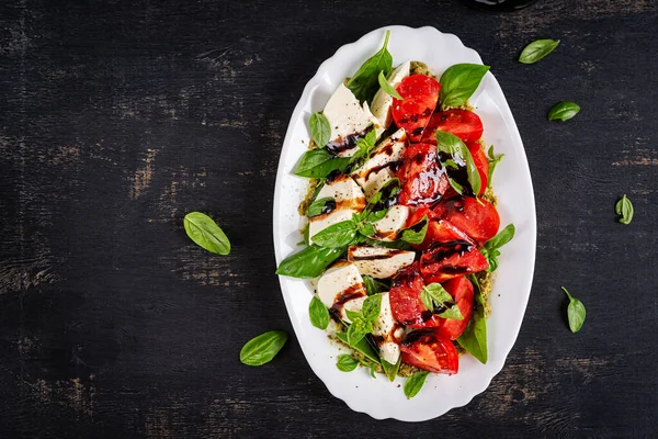 Konsept tasarım için domates salatası. Karanlık arka plan, yakın plan. Yemek konsepti. Üst görünüm