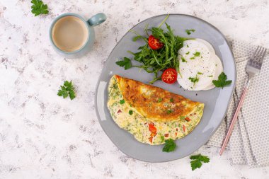 Domatesli omlet ve tabakta salata. Frittata - İtalyan omleti. Keto, ketojenik diyet. Üst görünüm