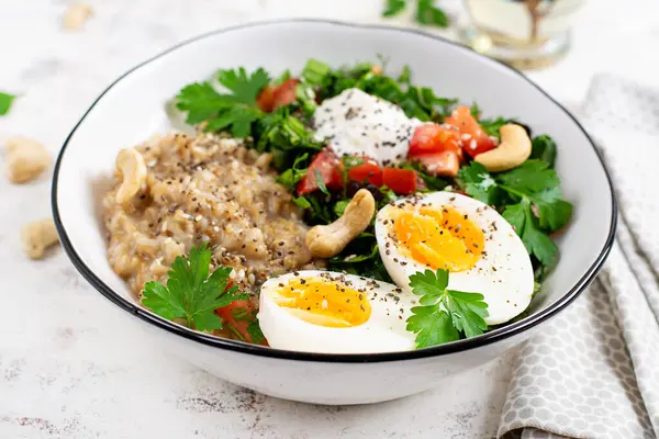 朝食は卵と新鮮なサラダでオートミールのお粥を提供しています 健康的なバランスの取れた食べ物 トレンディな食べ物 ストック画像