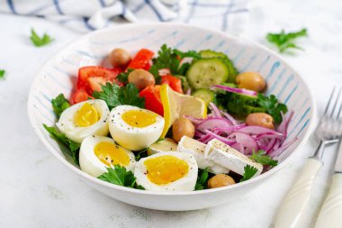 Kahvaltıda. Yunan salatası ve haşlanmış yumurta. Domates, salatalık, zeytin, roka ve peynirli taze sebze salatası..