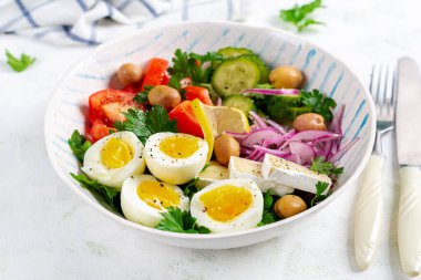 Kahvaltıda. Yunan salatası ve haşlanmış yumurta. Domates, salatalık, zeytin, roka ve peynirli taze sebze salatası..