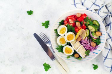Kahvaltıda. Yunan salatası ve haşlanmış yumurta. Domates, salatalık, zeytin, roka ve peynirli taze sebze salatası. Moda yemekler. Üst manzara, düz uzanma