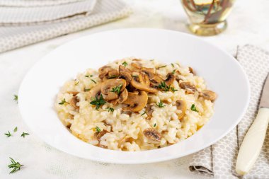 Tabağında mantar olan lezzetli risotto tabağı. Mantarlı pirinç lapası ve tmyne. Sıcak yemek, İtalyan mutfağı..