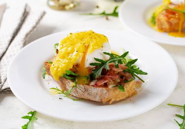 Kahvaltıda. Jambonlu sandviç, haşlanmış yumurta, soğan ve hafif arkaplanda roka.