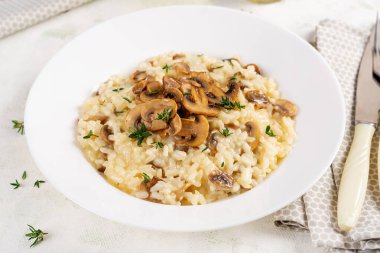 Tabağında mantar olan lezzetli risotto tabağı. Mantarlı pirinç lapası ve tmyne. Sıcak yemek, İtalyan mutfağı..