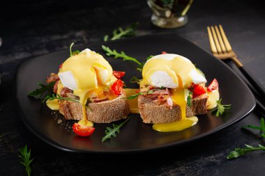 Kahvaltıda. Jambonlu sandviç, haşlanmış yumurta, soğan ve arkaplanda roka.