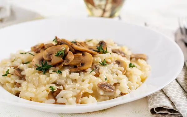 皿にキノコが付いているおいしいリゾットが付いている料理 真菌とタミンが付いている米のお粥 ホットディッシュ イタリア料理 ロイヤリティフリーのストック画像
