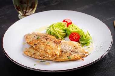 Izgara balık filetosu ve kabaklı makarna. Sağlıklı gıda konsepti.