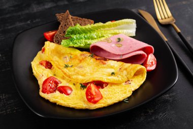 Domatesli omlet ve peynirli ekmek ve sosis..