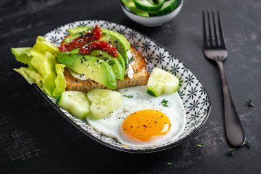 Sevgililer Günü için romantik bir kahvaltı. Avokado ve krem peynirli kızarmış yumurta ve tost..