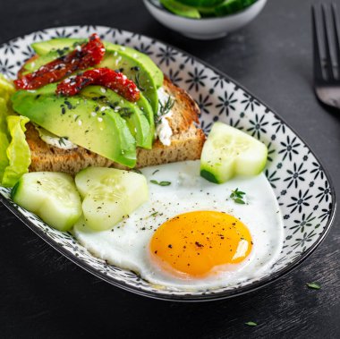Sevgililer Günü için romantik bir kahvaltı. Avokado ve krem peynirli kızarmış yumurta ve tost..