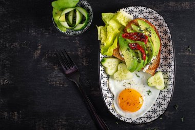 Sevgililer Günü için romantik bir kahvaltı. Avokado ve krem peynirli kızarmış yumurta ve tost. Üst görünüm
