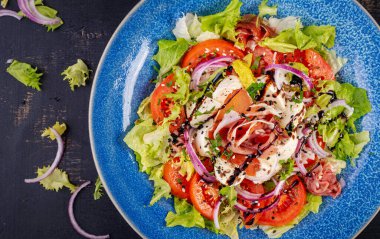 Prosciutto, mozzarella, domates ve kırmızı soğanlı salata. Sağlıklı beslenme. Keto, ketojenik diyet. Üst görünüm