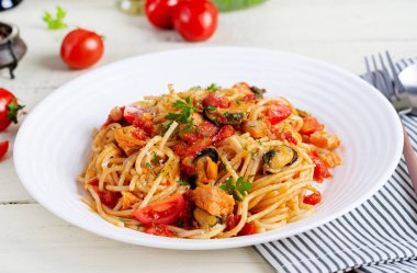 Klasik İtalyan spagetti soslu midye ve somon balıklı beyaz masa. Marinara soslu spagetti makarna..