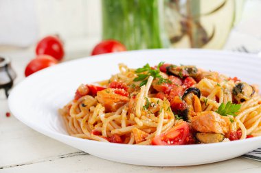 Klasik İtalyan spagetti soslu midye ve somon balıklı beyaz masa. Marinara soslu spagetti makarna..
