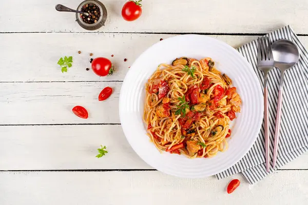 Klasik İtalyan spagetti soslu midye ve somon balıklı beyaz masa. Marinara soslu spagetti makarna. Üst görünüm, genel görünüm