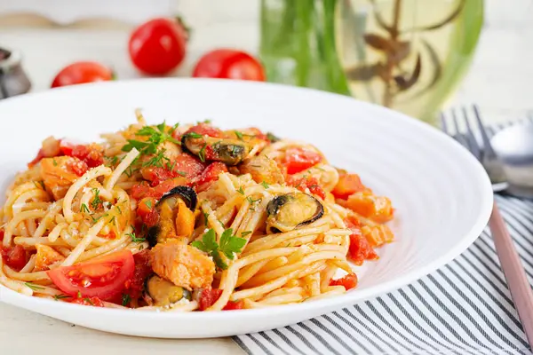 Classic italian pasta spaghetti marinara with mussels and salmon on white table. Spaghetti pasta with sauce marinara.