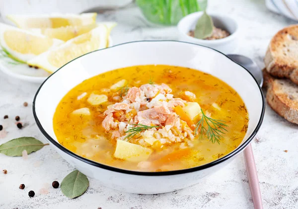 Fish soup with salmon, vegetables and rice in white bowl. Salmon soup.