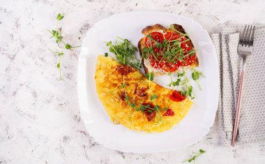 Peynirli omlet ve beyaz tabakta domatesli tost. Frittata - İtalyan omleti. Üst manzara, düz uzanma