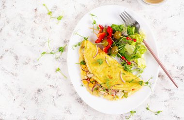 Sağlıklı kahvaltı. Omletli Quesadilla, tavuk filetosu, mısır ve taze salata. Keto, ketojenik öğle yemeği. Üst görünüm