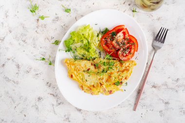 Sağlıklı kahvaltı. Omletli Quesadilla, pastırma ve domates salatası. Keto, ketojenik öğle yemeği. Üst görünüm