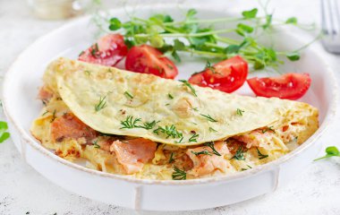 Sağlıklı kahvaltı. Omlet, somon ve dilimlenmiş domatesli Quesadilla. Keto, ketojenik öğle yemeği..