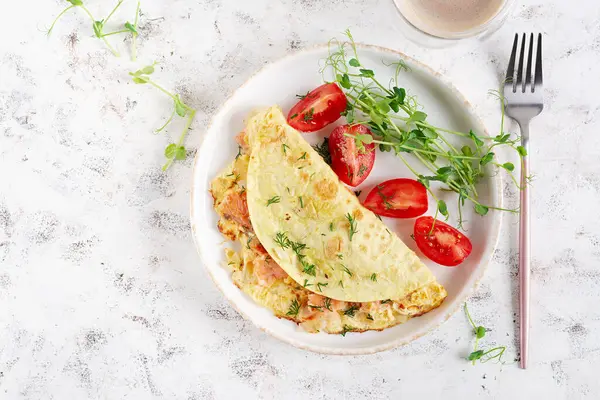 Sağlıklı kahvaltı. Omlet, somon ve dilimlenmiş domatesli Quesadilla. Keto, ketojenik öğle yemeği. Üst görünüm