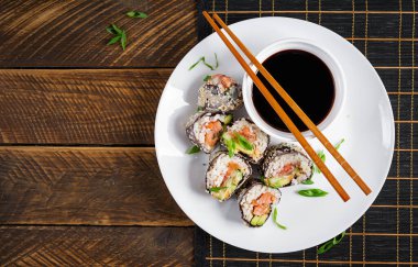 Nori, suşi pilavı, somon, salatalık, avokado, sriracha ve susamlı mayonez. Üst görünüm