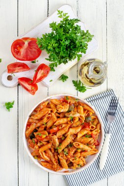 Beyaz ahşap masada sebzeli klasik İtalyan makarna arrabbiata. Soslu arrabbiata soslu makarna. Üst görünüm, genel görünüm