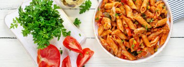 Beyaz ahşap masada sebzeli klasik İtalyan makarna arrabbiata. Soslu arrabbiata soslu makarna. Üst görünüm, afiş