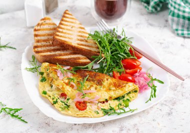 Healthy breakfast. Omelette with cheese, tomatoes   and green herbs. Omelette, salad and toast. Keto, ketogenic lunch.