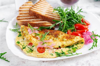 Healthy breakfast. Omelette with cheese, tomatoes   and green herbs. Omelette, salad and toast. Keto, ketogenic lunch.