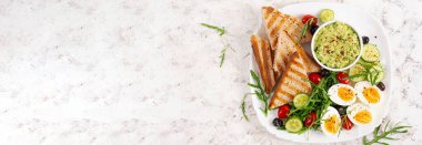 Healthy breakfast. Boiled egg, guacamole, toast and fresh salad. Top view, above