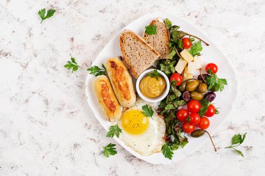 Kızarmış yumurta, ev yapımı tavuk sosisi, tost ve taze salata. Keto, paleo kahvaltısı. Üst manzara, düz uzanma