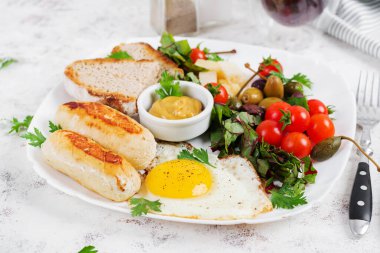 Kızarmış yumurta, ev yapımı tavuk sosisi, tost ve taze salata. Keto, paleo kahvaltı..