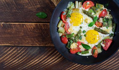 Vejetaryen kahvaltısı. Kızarmış yumurta ve peynirli kuşkonmaz. Ketogenik diyet. Sağlıklı yiyecekler. Üst manzara, düz uzanma