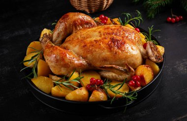 Fırında tavuk ya da hindi. Kızarmış tavuk, patates ve Noel süsü. Masa ayarı. Kapat.
