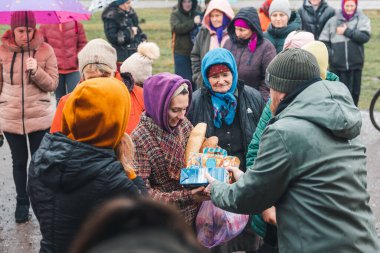 Kherson Rejimi, Ukrayna - Aralık 2022. Gönüllülerden insani yardım, insanlar yiyecek, giyecek ve hijyen ürünleri alıyorlar