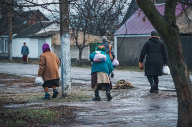 Kherson Rejimi, Ukrayna - Aralık 2022. Gönüllülerden yardım aldıktan sonra köylüler evlerine dönüyorlar.